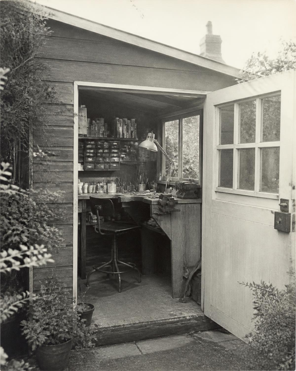 Archival photograph of a garden workshop with a jeweller's bench